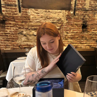 Woman looking at a menu in a restaurant with a brick wall background