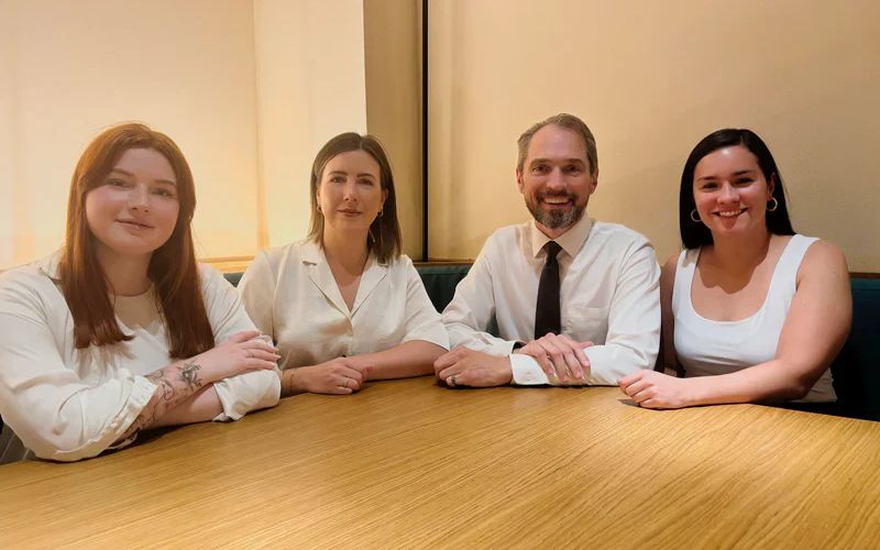 The four lighthouse commerce team members sitting at a table